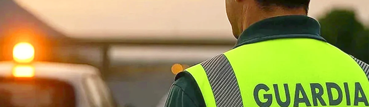 Agente de tráfico verificando la conexión de una baliza V16 en el techo de un coche.